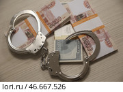 Наручники и банкноты номиналом 5000 российских рублей и 100 долларов США. А. Стоковое фото, фотограф Белкин/Бизнес Online / ТАСС / Фотобанк Лори