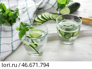 Стакана воды, наполненной огурцом, на белом деревянном столе. Стоковое фото, фотограф Pixel_shot / Фотобанк Лори