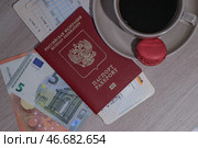 Заграничный паспорт гражданина Российской Федерации, посадочные талоны и банкноты номиналом 5 и 10 евро. Стоковое фото, фотограф Сергей Булкин/NEWS.ru / ТАСС / Фотобанк Лори