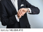 Красивый модный человек в формальной одежде, глядя на часы на светлом фоне, близком расстоянии. Стоковое фото, фотограф Pixel_shot / Фотобанк Лори