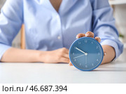 Деловая женщина касается будильника на столе, крупным планом. Концепция управления временем. Стоковое фото, фотограф Pixel_shot / Фотобанк Лори