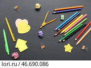Калькулятор с различными канцелярскими принадлежностями на черной меловой доске. Стоковое фото, фотограф Pixel_shot / Фотобанк Лори