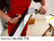 Мужской декоратор с шпателями работает в комнате, крупным планом. Стоковое фото, фотограф Pixel_shot / Фотобанк Лори