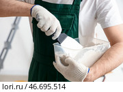 Мужчина-декоратор с шпателью и штукатуркой работает в комнате, крупным планом. Стоковое фото, фотограф Pixel_shot / Фотобанк Лори