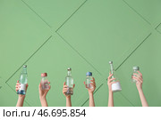 Женщины, держащие бутылки с чистой водой на зеленом фоне. Стоковое фото, фотограф Pixel_shot / Фотобанк Лори