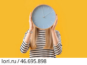 Молодая женщина с часами на желтом фоне. Концепция сроков выполнения. Стоковое фото, фотограф Pixel_shot / Фотобанк Лори