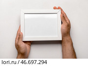 Мужчина, держащий пустую фоторамку на белом фоне. Стоковое фото, фотограф Pixel_shot / Фотобанк Лори