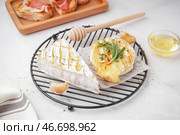 Сетка с вкусным запеченным сыром Камамбер на сером фоне. Стоковое фото, фотограф Pixel_shot / Фотобанк Лори