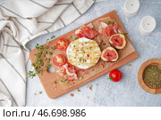 Деревянная доска с вкусным запеченным сыром Камамбер на светлом фоне. Стоковое фото, фотограф Pixel_shot / Фотобанк Лори