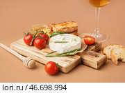 Деревянная доска с вкусным запеченным сыром Камамбер на коричневом фоне. Стоковое фото, фотограф Pixel_shot / Фотобанк Лори