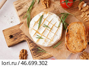 Деревянная доска с вкусным запеченным сыром Камамбер на светлом фоне. Стоковое фото, фотограф Pixel_shot / Фотобанк Лори