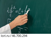 Женский учитель пишет математическую формулу на доске в классе, крупным планом. Стоковое фото, фотограф Pixel_shot / Фотобанк Лори