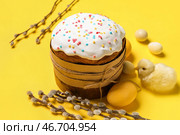 Композиция с вкусным куличом, крашеными яйцами, ветками вербы и игрушечным цыпленком на желтом фоне. Стоковое фото, фотограф Pixel_shot / Фотобанк Лори