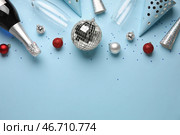 Дискобол, бутылка шампанского, елочные игрушки и конфетти на синем фоне. Новогоднее празднование. Стоковое фото, фотограф Pixel_shot / Фотобанк Лори