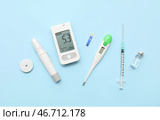 Глюкометр с ручкой для ланцета, сенсор глюкозы, инсулин и термометр на синем фоне. Концепция диабета. Стоковое фото, фотограф Pixel_shot / Фотобанк Лори