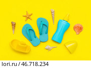 Красивый композиционный снимок с солнцезащитным кремом и пляжными аксессуарами для детей на желтом фоне. Стоковое фото, фотограф Pixel_shot / Фотобанк Лори