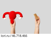Руки с женской маткой и таблетками на сером фоне. Стоковое фото, фотограф Pixel_shot / Фотобанк Лори