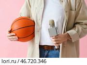 Мужчина-репортёр с микрофоном и мячом на розовом фоне, крупный план. Стоковое фото, фотограф Pixel_shot / Фотобанк Лори