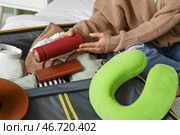 Молодая женщина упаковывает термос в чемодан дома, крупный план. Концепция путешествия. Стоковое фото, фотограф Pixel_shot / Фотобанк Лори