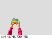 Ребенок с игрушкой-антистресс поп-ит на светлом фоне. Стоковое фото, фотограф Pixel_shot / Фотобанк Лори
