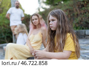 Sad girl feeling excluded from family gathering outdoors. Стоковое фото, фотограф Константин Шишкин / Фотобанк Лори