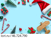 Рамка из игрушек, деревянный самолет и шапка Санты на синем фоне. Концепция рождественских каникул. Стоковое фото, фотограф Pixel_shot / Фотобанк Лори
