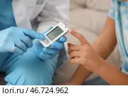 Диабетическая девочка с доктором, использующим глюкометр дома, крупным планом. Стоковое фото, фотограф Pixel_shot / Фотобанк Лори