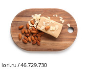 Деревянная доска с вкусной марципановой плиткой, миндальными орехами и хлопьями на белом фоне. Стоковое фото, фотограф Pixel_shot / Фотобанк Лори