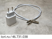 Белый блок питания и кабель микро USB на сером фоне. Адаптер питания, зарядное устройство для бытовой электроники. Стоковое фото, фотограф Sergei Gorin / Фотобанк Лори