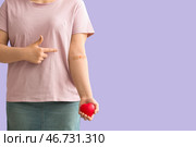 Донор крови с сердцем, указывающим на медицинский пластырь на сиреневом фоне. Стоковое фото, фотограф Pixel_shot / Фотобанк Лори