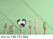 Женские руки со спортивным инвентарем, стетоскопом и очками на зеленом фоне. Концепция рака простаты. Стоковое фото, фотограф Pixel_shot / Фотобанк Лори
