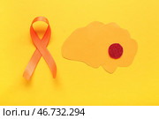 Бумажный мозг и оранжевая лента на желтом фоне. Месяц осведомленности о рассеянном склерозе. Стоковое фото, фотограф Pixel_shot / Фотобанк Лори