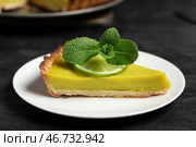 Тарелка с кусочком вкусного лаймового тарта на черном фоне. Стоковое фото, фотограф Pixel_shot / Фотобанк Лори