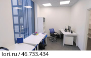 Modern compact office room with several workstations and bright artificial light. Стоковое фото, фотограф David Kashakhi / Фотобанк Лори