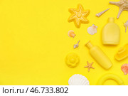 Красивый композиционный снимок с солнцезащитным кремом и пляжными аксессуарами для детей на желтом фоне. Стоковое фото, фотограф Pixel_shot / Фотобанк Лори