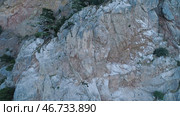 Top view of rocky steep wall with sparse vegetation on ledges. Стоковое фото, фотограф David Kashakhi / Фотобанк Лори