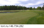 Golfers hitting golf shot with club on course while on summer vacation, aerial. Стоковое фото, фотограф David Kashakhi / Фотобанк Лори
