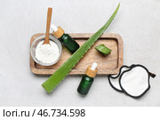 Деревянная доска с листьями алоэ вера, бутылками эфирного масла и порошком с ферментами на светлом фоне. Стоковое фото, фотограф Pixel_shot / Фотобанк Лори