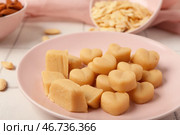 Тарелка с вкусными марципановыми конфетами и миндальными хлопьями на светлом кафельном столе, крупный план. Стоковое фото, фотограф Pixel_shot / Фотобанк Лори