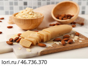 Разделочная доска с вкусным марципаном, миндальными орехами и хлопьями на светлом столе. Стоковое фото, фотограф Pixel_shot / Фотобанк Лори