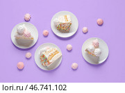Тарелки с кусочками вкусного днюхи и белковым кремом на лиловом фоне. Стоковое фото, фотограф Pixel_shot / Фотобанк Лори
