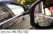 Blind Spot Monitoring system warning light icon in side view mirror of a modern vehicle. Стоковое фото, фотограф David Kashakhi / Фотобанк Лори