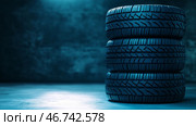 Stacked tires in a dimly lit warehouse showcasing detailed tread patterns. Стоковое AI-изображение, AI-художник Katsiaryna Repich / Фотобанк Лори