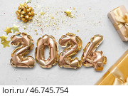 Композиция с фигурой 2024 из фольгированных воздушных шаров и подарочных коробок на сером фоне. Стоковое фото, фотограф Pixel_shot / Фотобанк Лори