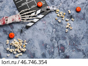 Попкорн, киношный хлопушка и хэллоуинская декорация на сером гранжевом фоне. Стоковое фото, фотограф Pixel_shot / Фотобанк Лори