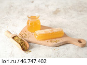 Деревянная доска с банкой меда, сотом и пчелиным пыльцой на светлом фоне. Стоковое фото, фотограф Pixel_shot / Фотобанк Лори