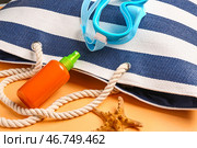 Бутылка солнцезащитного крема с сумкой и маской для сноркелинга на оранжевом фоне. Стоковое фото, фотограф Pixel_shot / Фотобанк Лори