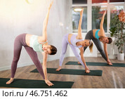 Young woman practicing twisting yoga postures at group class. Стоковое фото, фотограф Яков Филимонов / Фотобанк Лори