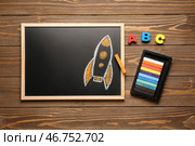 Доска с нарисованной ракетой, мелками и буквами на коричневом деревянном фоне. Стоковое фото, фотограф Pixel_shot / Фотобанк Лори