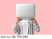 Женщина, закрывающая лицо ноутбуком на розовом фоне. Стоковое фото, фотограф Pixel_shot / Фотобанк Лори